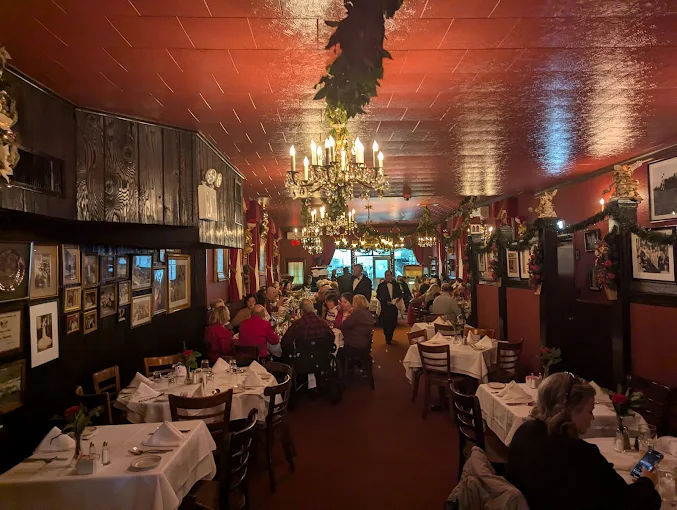 Bamonte’s dining room with chandeliers, red ceilings, and white tablecloths