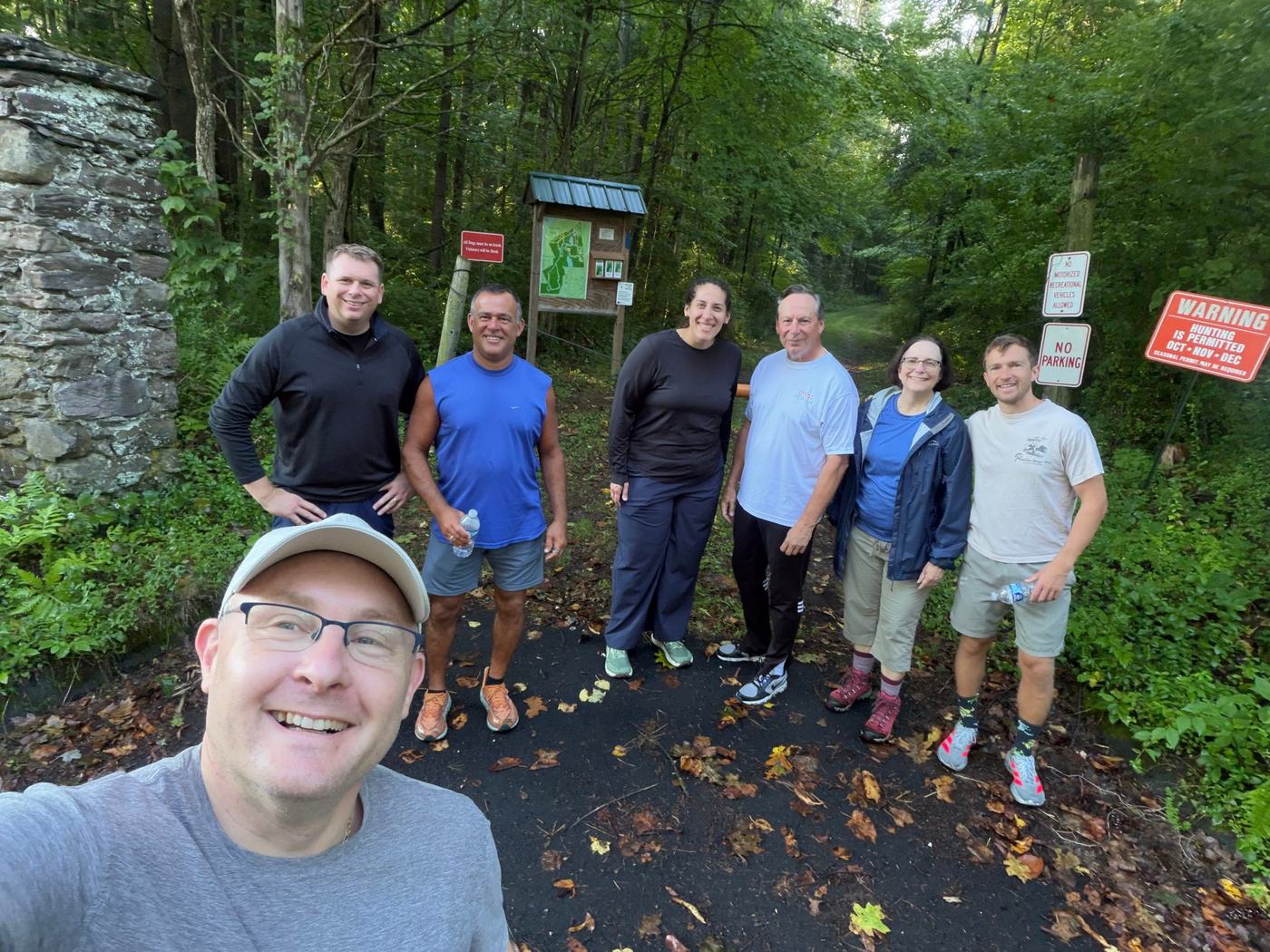 Guests smiling on a wooded trail during the 2026 retreat’s sunrise hike