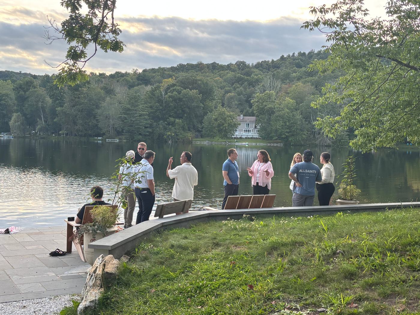 Retreat guests gathered beside the lake at dusk in 2026