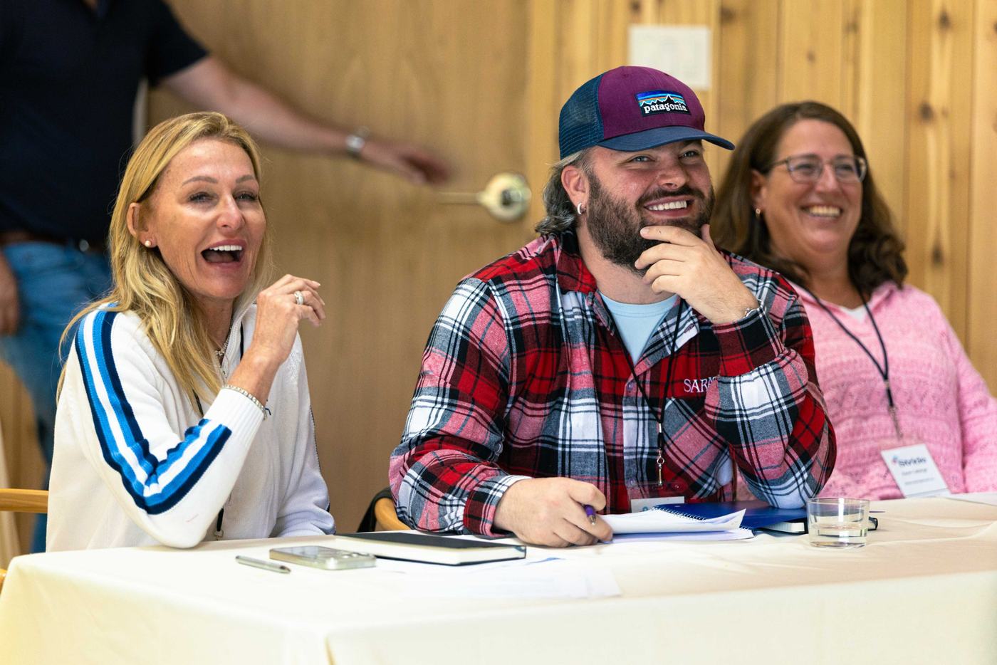 Three guests laughing together during a session at the 2026 retreat
